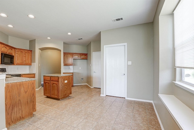 1108 Mourning Dove Dr, Burleson, TX 76028 - kitchen featuring visible vents, black microwave, recessed lighting, brown cabinets, and tasteful backsplash