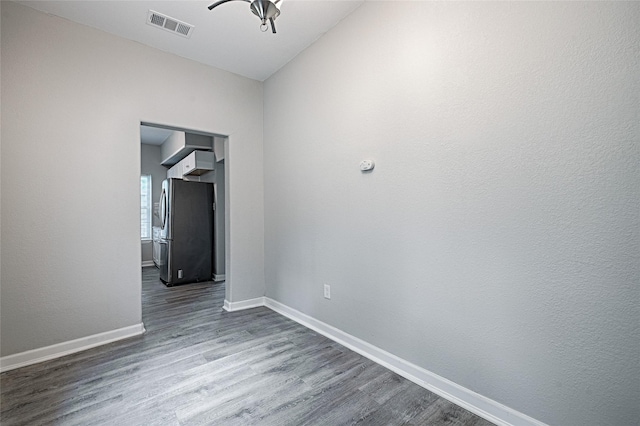 empty room with visible vents, wood finished floors, and baseboards