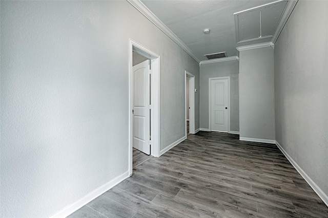 spare room featuring attic access, crown molding, visible vents, baseboards, and wood finished floors