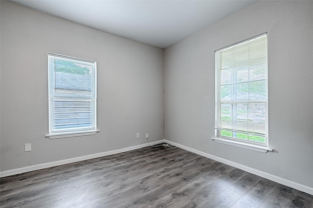 unfurnished room featuring baseboards and wood finished floors