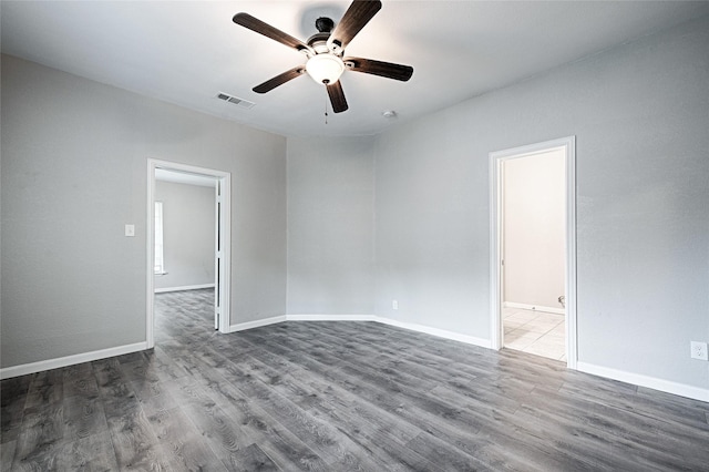 empty room featuring ceiling fan, baseboards, wood finished floors, and visible vents