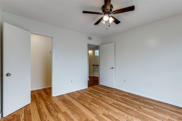 unfurnished bedroom with a ceiling fan, baseboards, visible vents, and light wood finished floors