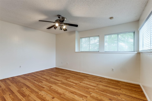 unfurnished room featuring baseboards, a textured ceiling, light wood finished floors, and ceiling fan