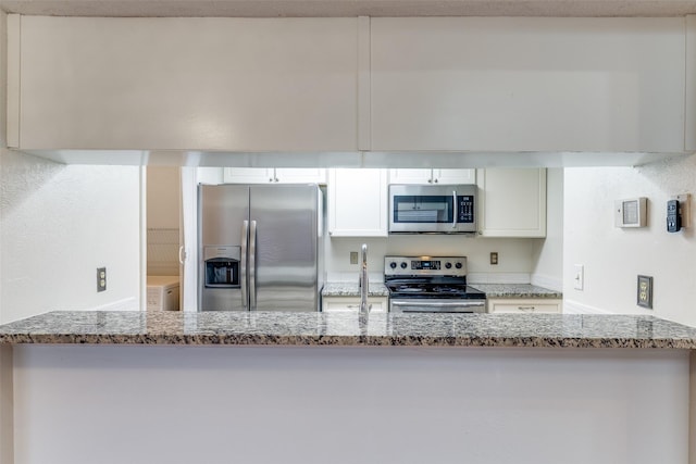 kitchen featuring appliances with stainless steel finishes, white cabinets, and light stone countertops