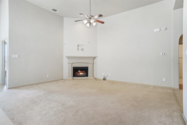 1441 Elkford Ln, Fort Worth, TX 76247 - unfurnished living room with light colored carpet, a lit fireplace, ceiling fan, arched walkways, and vaulted ceiling