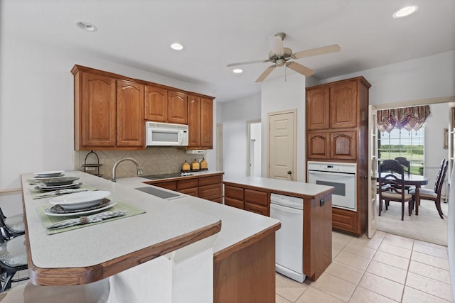 125 Deer Stream Ct, Azle, TX 76020 - kitchen with light tile patterned floors, white appliances, a ceiling fan, a peninsula, and backsplash