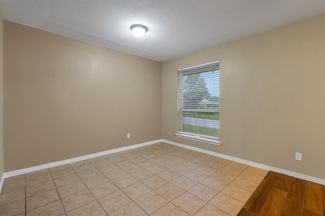 spare room with baseboards and a textured ceiling