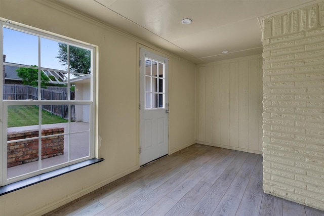 empty room with crown molding, recessed lighting, baseboards, and wood finished floors