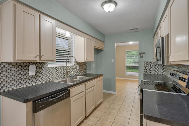 kitchen with a sink, dark countertops, and stainless steel appliances