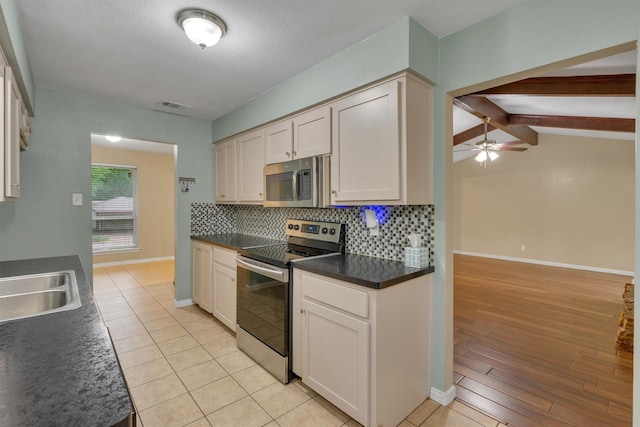 kitchen with ceiling fan, dark countertops, stainless steel appliances, backsplash, and visible vents