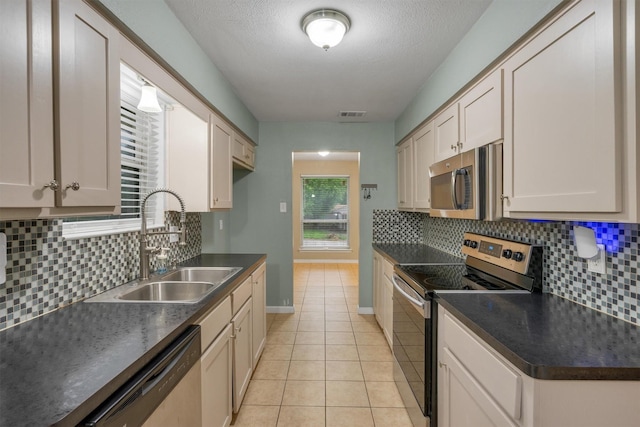 kitchen featuring a sink, dark countertops, tasteful backsplash, and stainless steel appliances