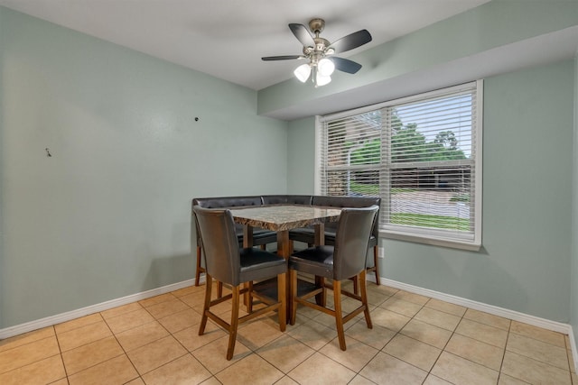 dining room with light tile patterned flooring, baseboards, and ceiling fan