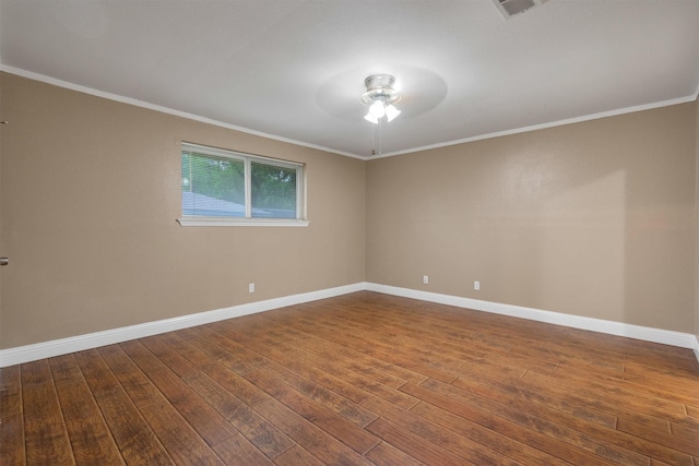 spare room featuring baseboards, ornamental molding, a ceiling fan, and dark wood finished floors