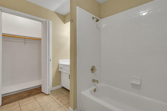 full bathroom featuring washtub / shower combination, vanity, tile patterned floors, baseboards, and a spacious closet