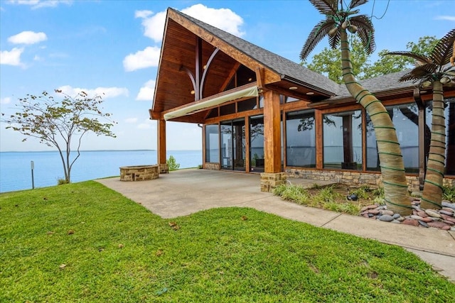 surrounding community with a lawn, a patio area, and a water view