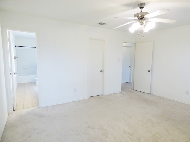 unfurnished bedroom with visible vents, ceiling fan, light carpet, and ensuite bathroom