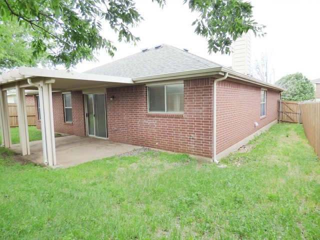 back of house with a chimney, a yard, a patio, and a fenced backyard