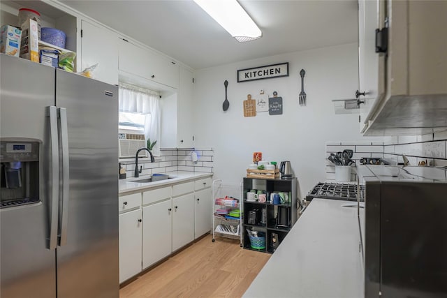 kitchen with a sink, light wood-style floors, tasteful backsplash, light countertops, and stainless steel fridge with ice dispenser