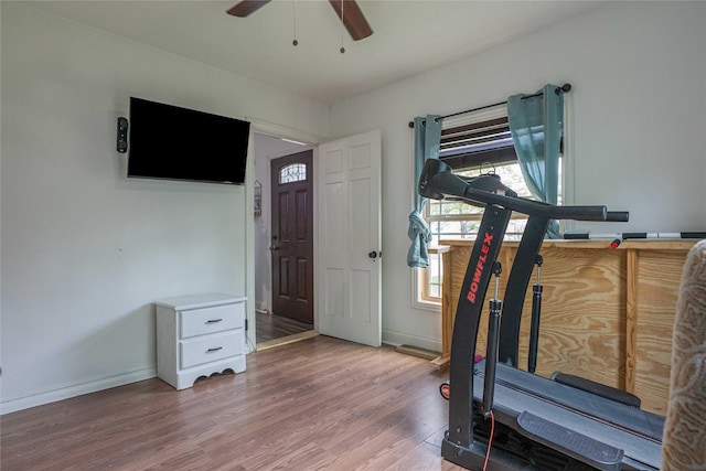 workout room with ceiling fan, baseboards, wood finished floors, and plenty of natural light
