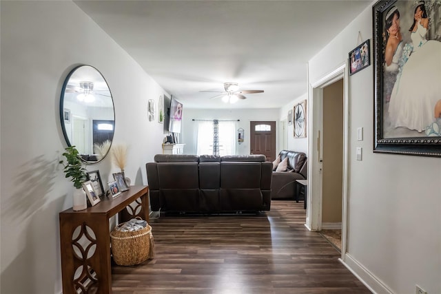 living area featuring ceiling fan, dark wood finished floors, and baseboards