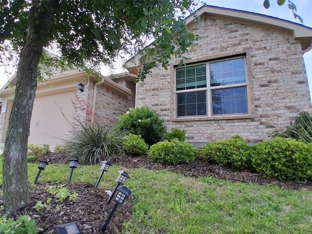 view of front of house featuring a garage, a front yard, and stone siding