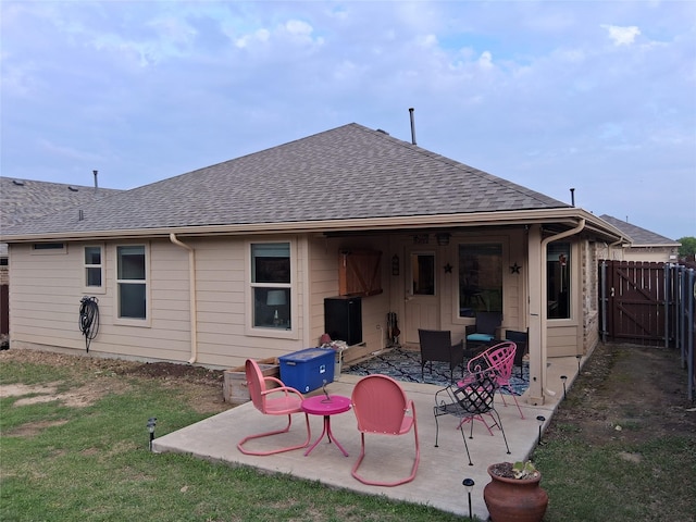 back of house with a patio, fence, a gate, and a shingled roof