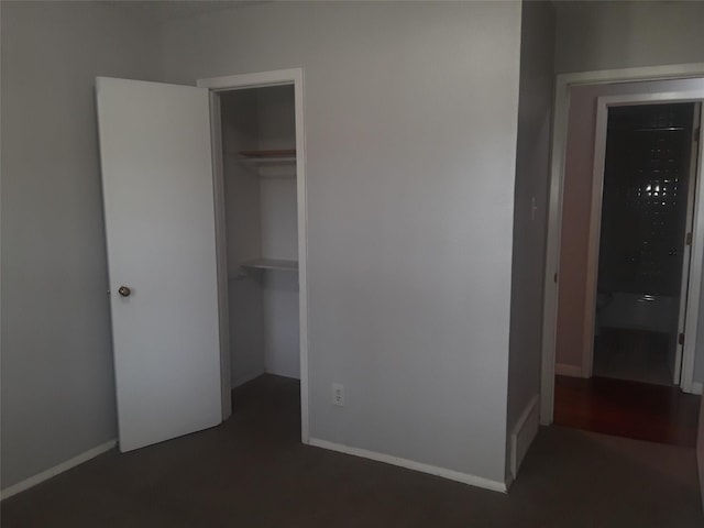 unfurnished bedroom featuring a walk in closet, baseboards, and a closet