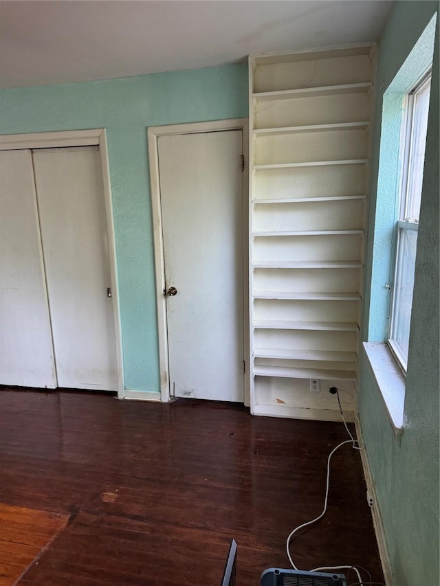 unfurnished bedroom featuring wood finished floors and a closet