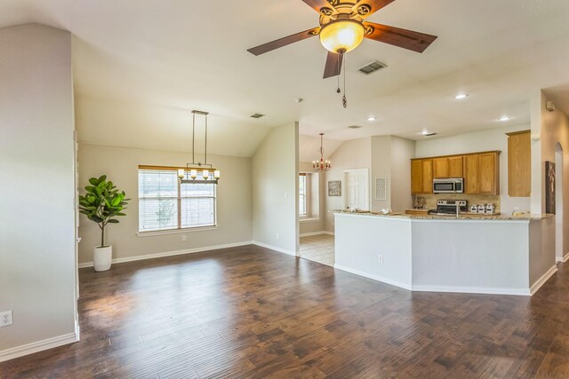kitchen with brown cabinets, visible vents, stainless steel appliances, vaulted ceiling, and ceiling fan with notable chandelier
