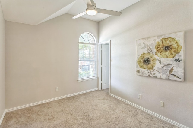 carpeted spare room with baseboards, ceiling fan, lofted ceiling, and plenty of natural light