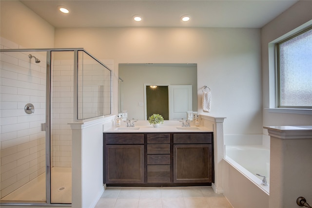 bathroom with double vanity, a sink, a garden tub, and a stall shower