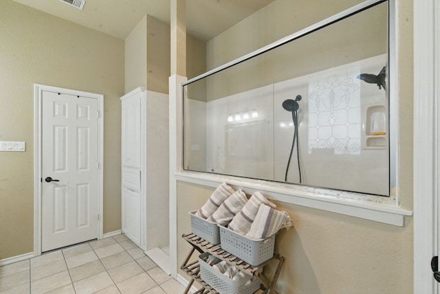 bathroom featuring walk in shower, tile patterned floors, and baseboards