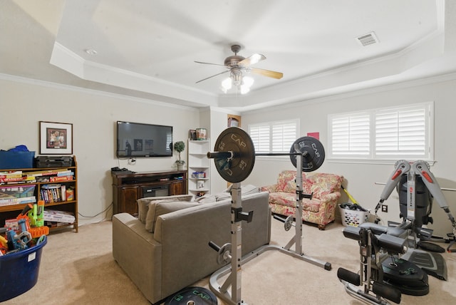 carpeted living area featuring crown molding, a ceiling fan, visible vents, and a raised ceiling
