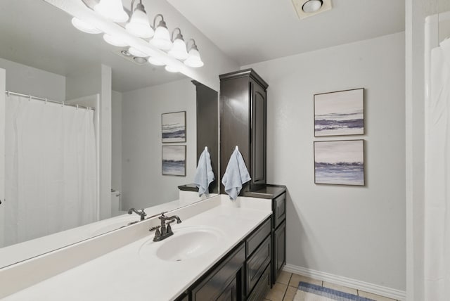 bathroom with tile patterned floors, vanity, and baseboards
