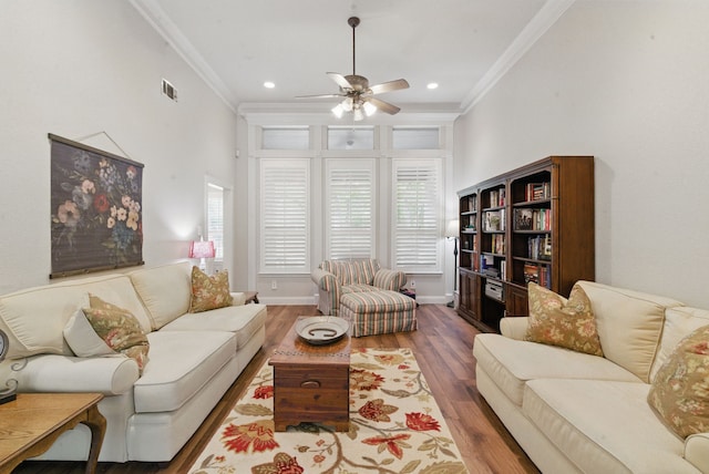 living room with crown molding, ceiling fan, a wealth of natural light, and wood finished floors