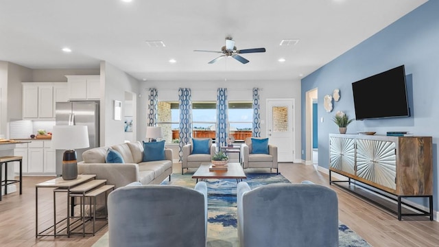 living room with light wood finished floors, a ceiling fan, visible vents, and recessed lighting