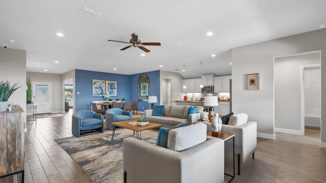living room with recessed lighting, wood finished floors, baseboards, visible vents, and a ceiling fan