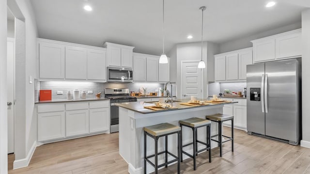 kitchen with light wood finished floors, recessed lighting, appliances with stainless steel finishes, and tasteful backsplash