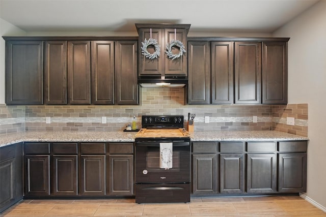 6309 Outrigger Rd, Fort Worth, TX 76179 - kitchen with black electric range, under cabinet range hood, decorative backsplash, dark brown cabinets, and light stone counters