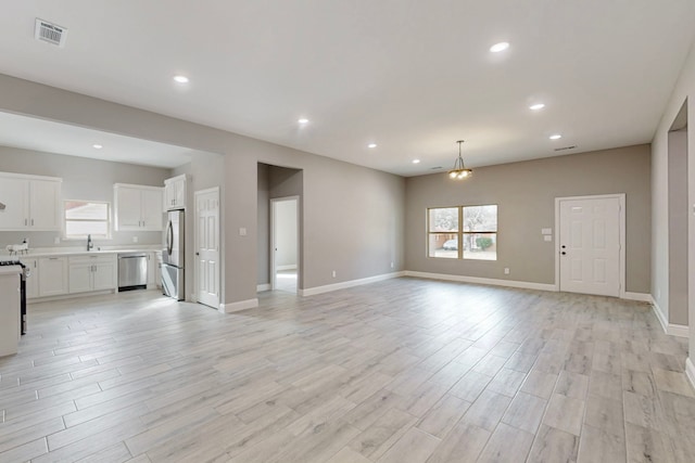 706 Poinsettia Dr, Lancaster, TX 75146 - unfurnished living room featuring healthy amount of natural light, light wood-style flooring, and recessed lighting