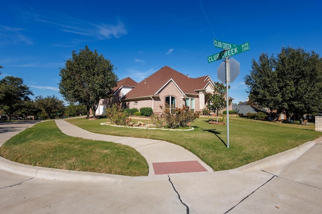 view of front facade featuring a front yard and brick siding