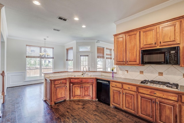kitchen featuring a sink, visible vents, black appliances, a peninsula, and brown cabinetry