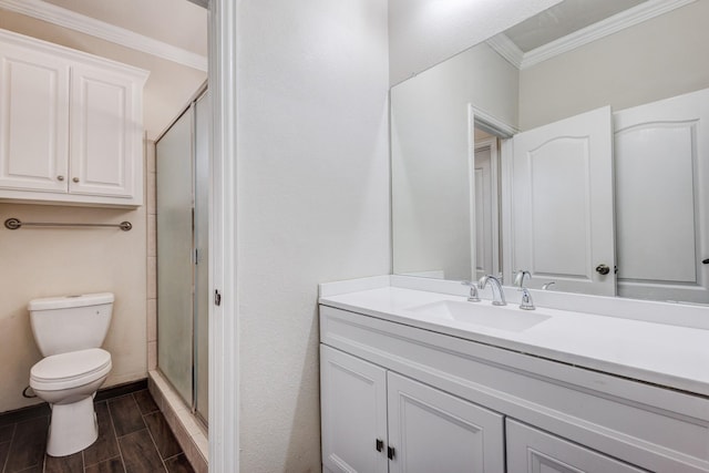 bathroom with a shower stall, vanity, wood tiled floor, toilet, and ornamental molding