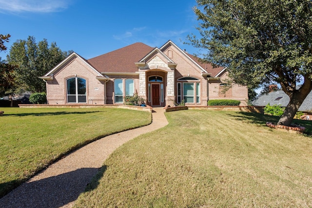 view of front of house featuring a front yard and brick siding