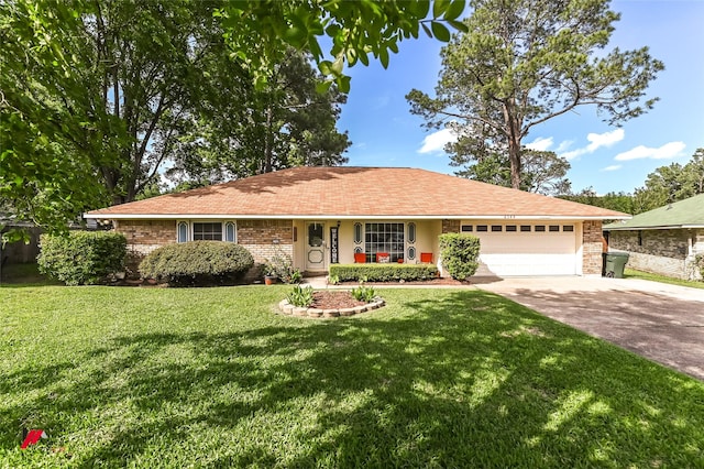 ranch-style house featuring a front yard, an attached garage, concrete driveway, and brick siding
