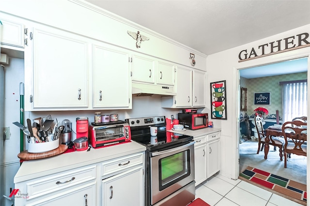 kitchen featuring stainless steel electric range oven, a toaster, under cabinet range hood, light countertops, and light tile patterned flooring