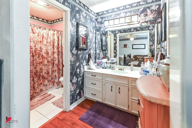 bathroom with a shower with curtain, vanity, tile patterned floors, toilet, and wallpapered walls