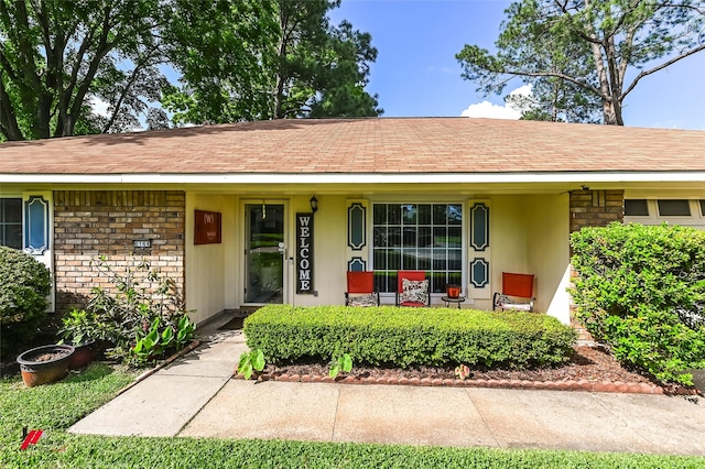 view of front of property featuring a shingled roof, a porch, and stucco siding