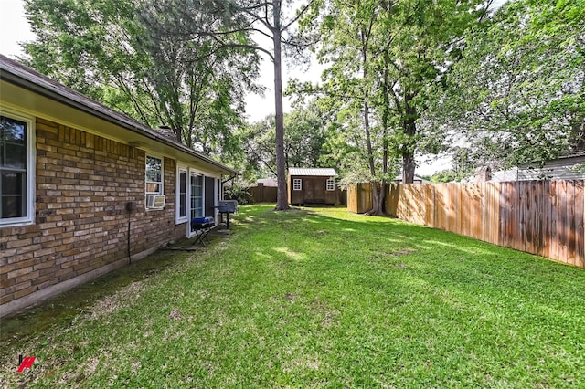 view of yard featuring an outbuilding, a storage unit, and a fenced backyard