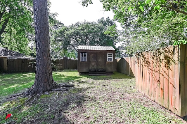 view of yard with a storage unit, an outdoor structure, and a fenced backyard